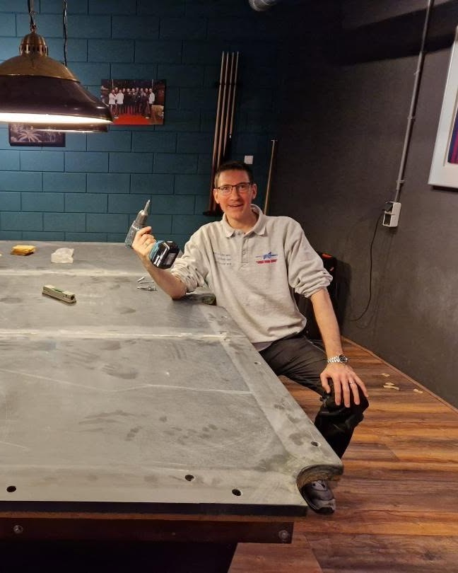 Date van Leeuwen sitting on a table slate holding a drill