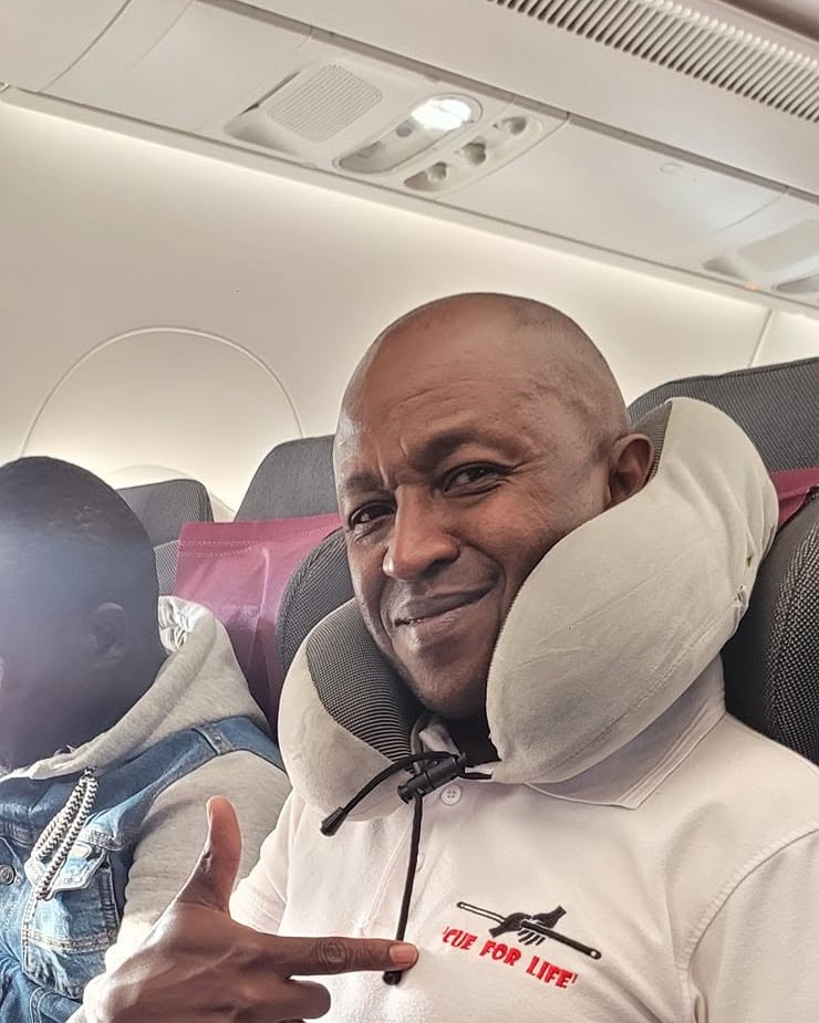Peter Kinyua pointing at the Cue for Life logo on his shirt